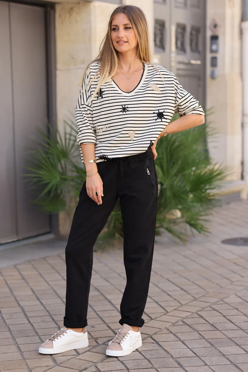 Jogging noir en coton ceinture élastique et poches zips liseré broderie chevrons