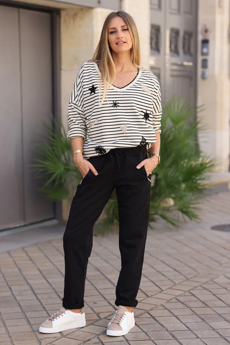 Jogging noir en coton ceinture élastique et poches zips liseré broderie chevrons